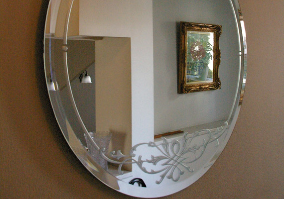 エッチングミラー；玄関ホール<br>お客様を迎え入れる空間に誂えた鏡。外縁の面取りとクラシカルな彫刻が優美な雰囲気をたたえます。