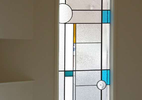 ステンドグラス；玄関ホールFIX窓<br>透明系と落ち着いた色ガラスを織り交ぜて制作した上質なステンドグラス。<br>日々の暮らしの中に光を透した感動が続くシンプルなデザイン。