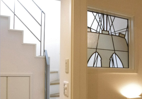 ステンドグラス；階段室FIX窓<br>思い出を込めてデザインしたステンドグラス。<br>長年住み慣れた外国の街の印象を暮らしの中に感じられる設え。