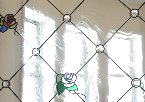ステンドグラス；玄関ホールFIX窓<br>住宅に併設されたサロンのステンドグラス。<br>サロンの象徴の薔薇をデザインの一部に。